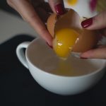 Mulher de esmalte quebrando ovos