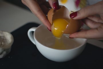 Mulher de esmalte quebrando ovos